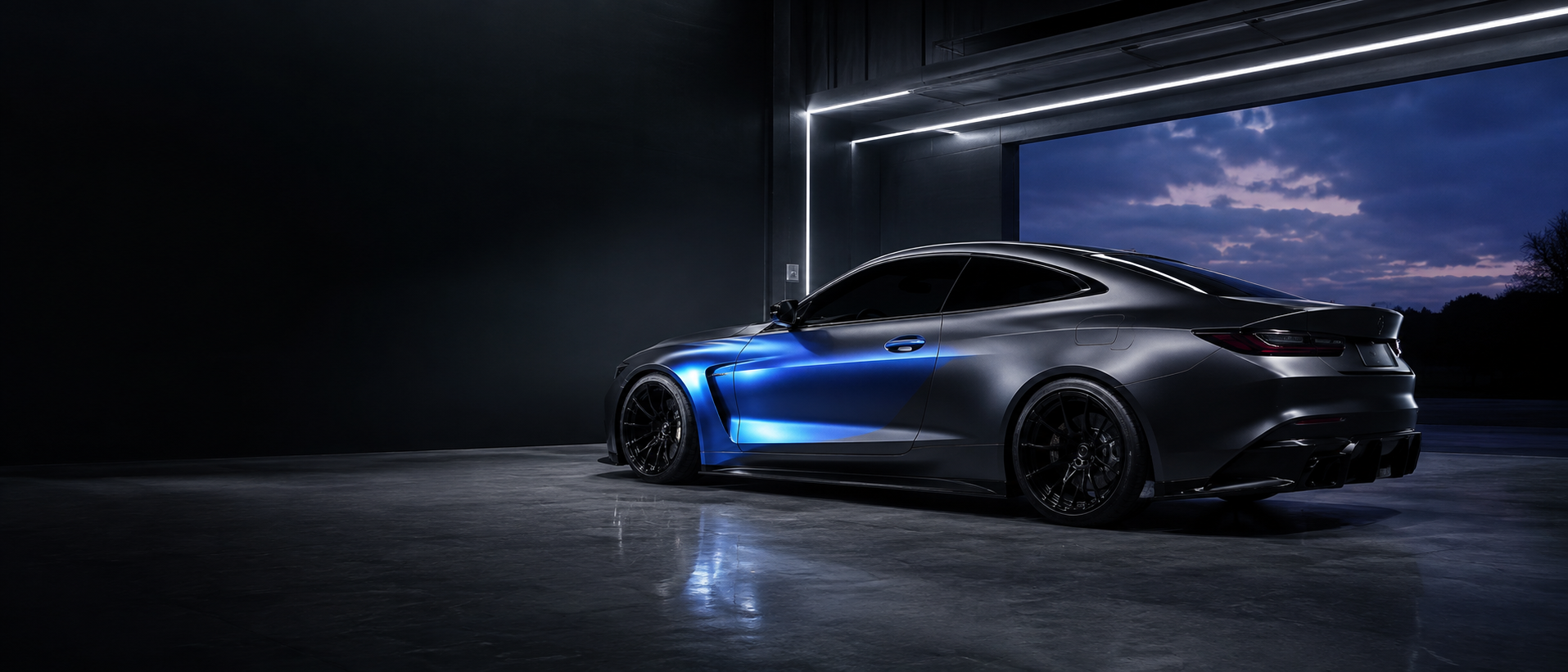 Conceptual graphite coupe with a cobalt wrap accent in a precision automotive studio